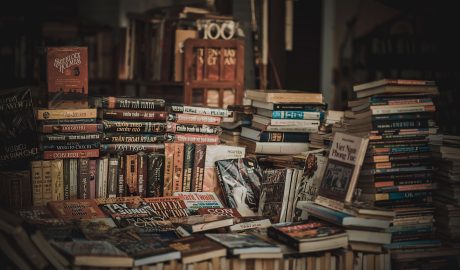 Stosy książek w księgarni – ilustracja do zestawienia literatury grozy na Halloween